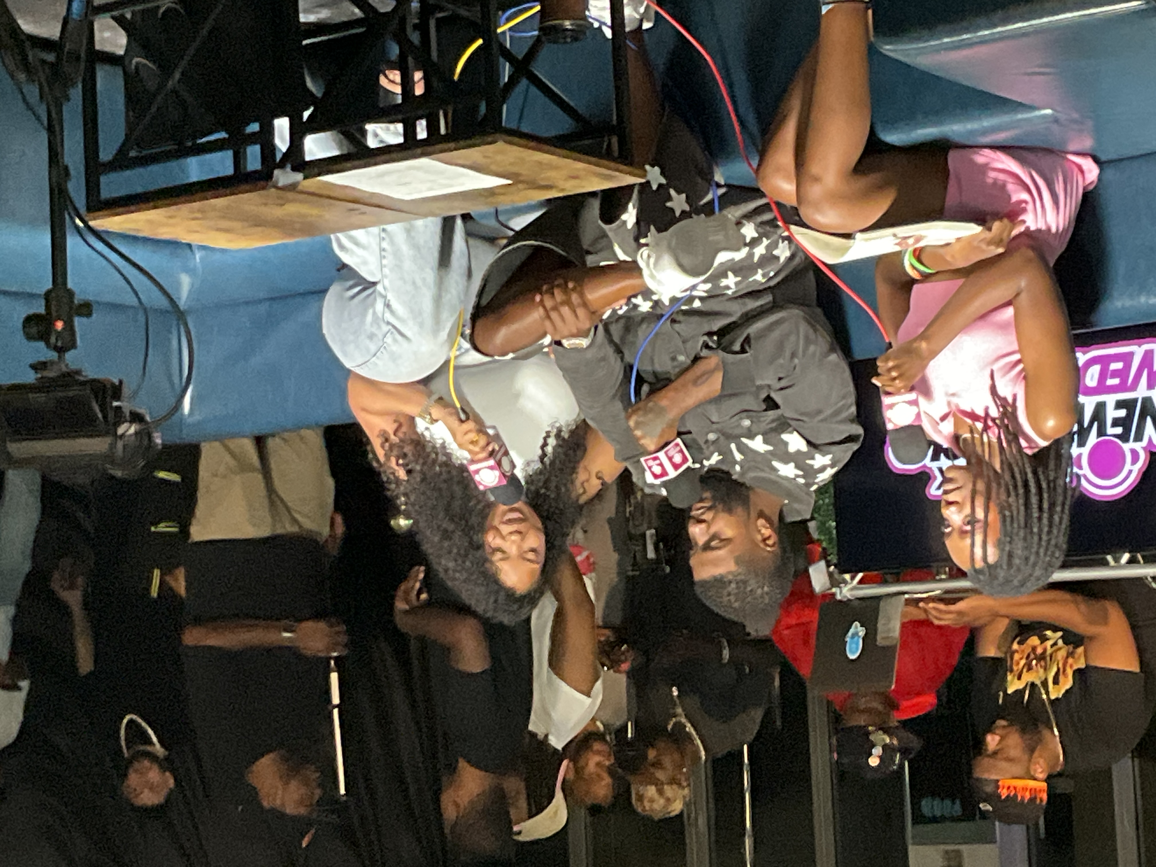 Live production event scene with people, cameras, chandeliers, and lounge seating.